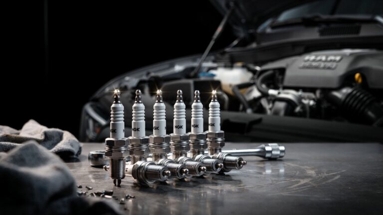 Best spark plugs for Ram 1500 – set of NGK iridium spark plugs with installation tools in front of a Ram 1500 HEMI engine bay